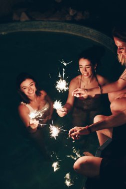 Neşeli arkadaşlar havuz kenarında ışıldıyor