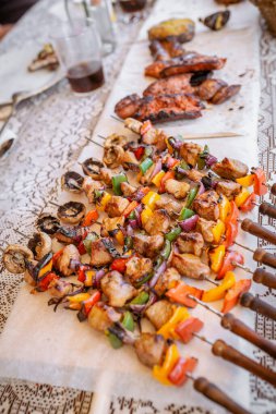 Tabağın en üst görüntüsünde mangaldan alınmış domuz eti, sebze ve sucuklu sucuk var.