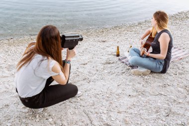 Gitar çalan arkadaşını vuran genç bir kadın.