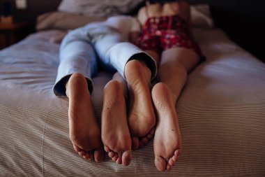 Tarz sahibi yatak odasındaki rahat yatakta tanınmayan bir kadın ve erkek yan yana yatıyorlar. 