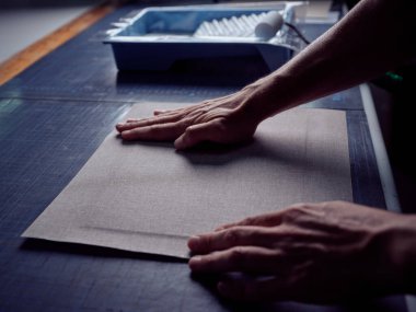 Masanın yanında dururken kağıt kağıtları kontrol etmek için el kullanan tanınmayan kişi