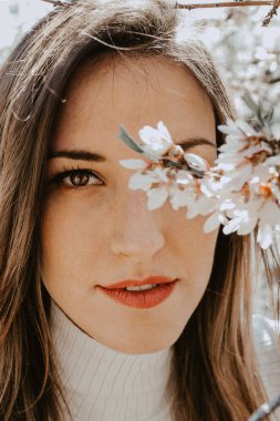 Bahçedeki ağaçların arasında mutlu bir kadın