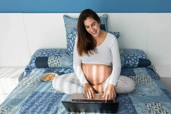 Smiling Pregnant Female Speaking Video Call Netbook While Sitting Comfortable — Stok fotoğraf