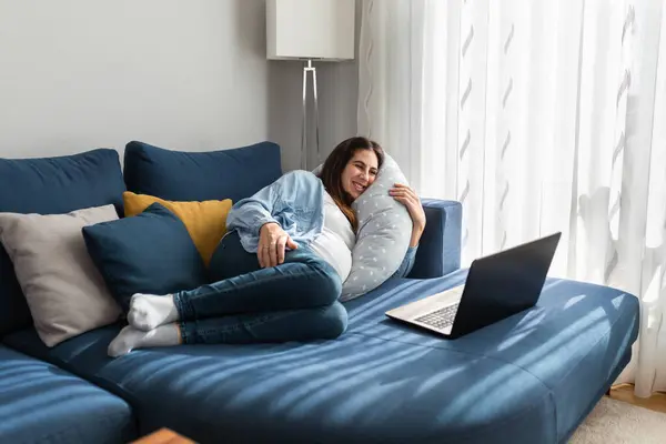 Delighted Pregnant Female Lying Comfortable Sofa Watching Funny Video Netbook — Stock Photo, Image