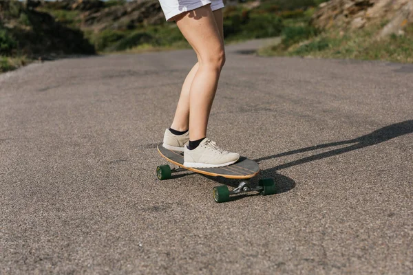 Cropped Unrecognizable Young Female Riding Longboard Asphalt Road Hills Cloudy — Stock Photo, Image