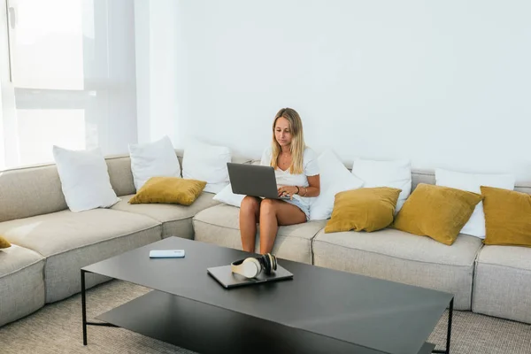 Mulher Concentrada Desgaste Casual Digitando Netbook Enquanto Sentado Sofá Confortável — Fotografia de Stock