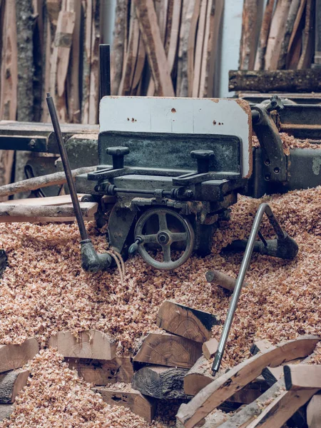 農村部の木製プランクの山近くのシェービングに木材を使用するための特別な黒金属工作機械 — ストック写真