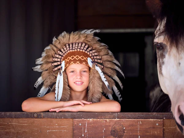 Cheerful Kid Wearing Authentic Native American Headwear Leaning Barrier Stable — Stock Photo, Image