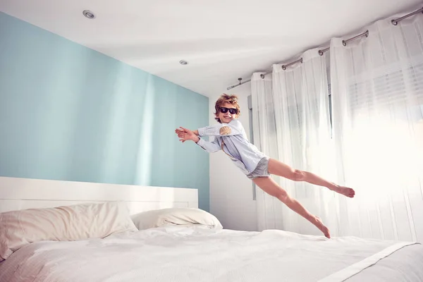 Full Body Barefoot Excited Boy Sunglasses Jumping Comfortable Bed Light — Stock Photo, Image