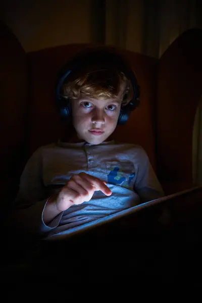 Stock Vertical Photo Child Headphones Sitting Sofa Touching Screen Ipad — Stock Photo, Image