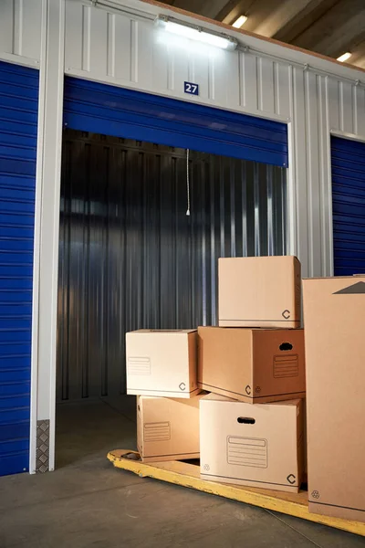 Endüstriyel bir binada, geri dönüşümlü karton kutuları palet rafının üstünde olan girişimcilere ya da kişilere kiralanacak bir depo.