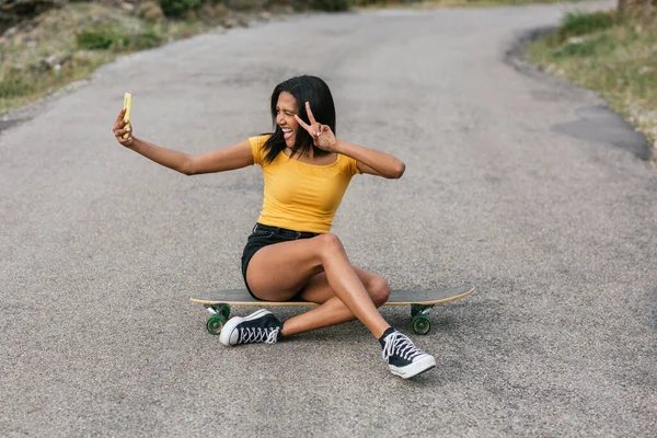 Εθνοτική Θηλυκό Λήψη Selfie Στο Smartphone Ενώ Κάθεται Longboard Άσφαλτο — Φωτογραφία Αρχείου