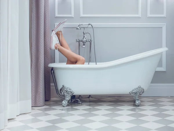 욕실에서 다리를 욕조에 운동화에서 인식할 여성의 — 스톡 사진