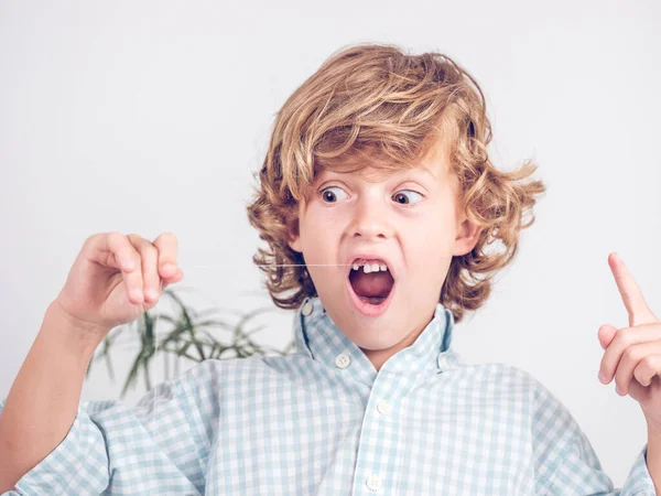 Podekscytowany Nastolatek Kręcone Włosy Chłopiec Patrząc Nici Podczas Drgając Zęba — Zdjęcie stockowe