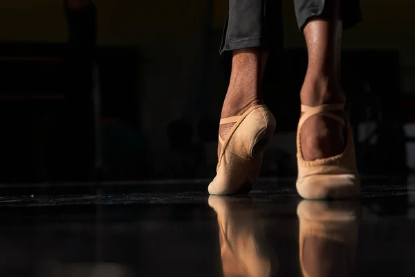 Feet of a professional ballet dancer in a warm-up before rehearsal