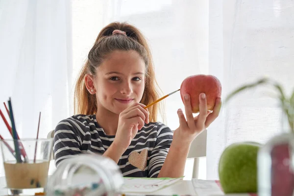 Περιεχόμενο Κορίτσι Κοιτάζοντας Μακριά Ενώ Ζωγραφική Κόκκινο Μήλο Στο Τραπέζι — Φωτογραφία Αρχείου