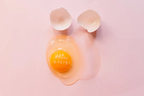 Raw Broken Egg Text Happy Easter Yellow Yolk Eggshells Pink — Stock Photo, Image