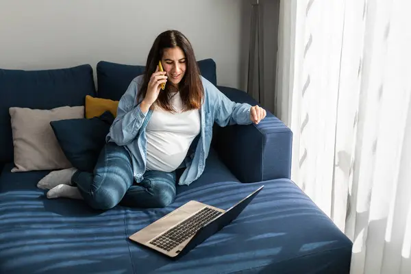 Pregnant Female Freelancer Sitting Sofa Laptop Living Room Speaking Mobile — Stok fotoğraf
