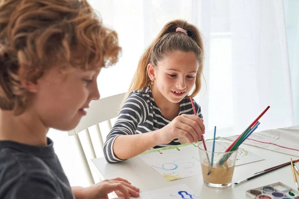 Crianças Adoráveis Pintando Papel Com Pincéis Enquanto Sentado Mesa Com — Fotografia de Stock
