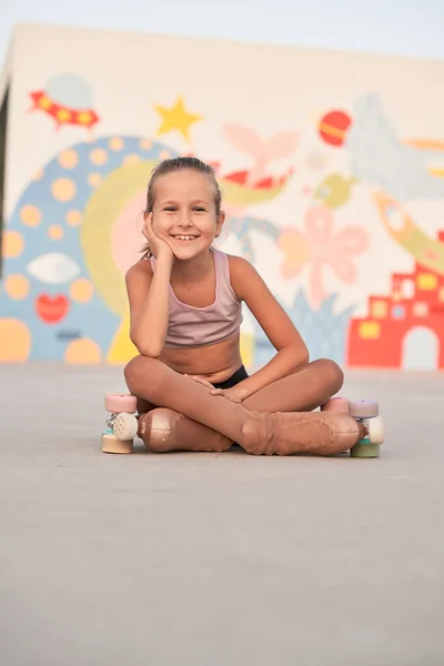 Portret Van Een Glimlachend Meisje Activewear Quad Rolschaatsen Zittend Sportveld — Stockfoto