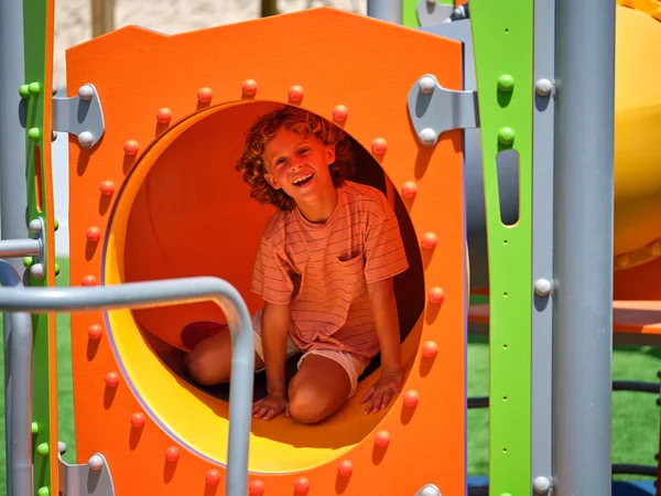 Criança Adorável Sentado Slide Tubo Colorido Enquanto Sorri Feliz Olhando — Fotografia de Stock