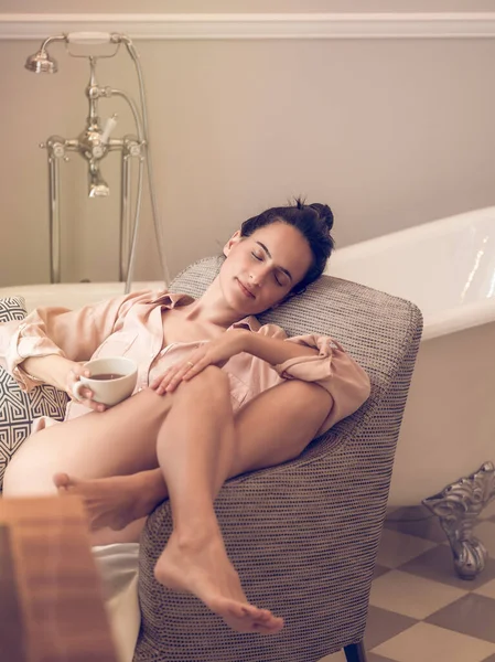 잠옷을 여성의 시간에 욕실에 의자에서 — 스톡 사진