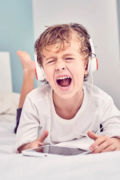 Boso Chłopiec Mokrymi Włosami Leżący Łóżku Krzyczący Głośno Podczas Słuchania — Zdjęcie stockowe