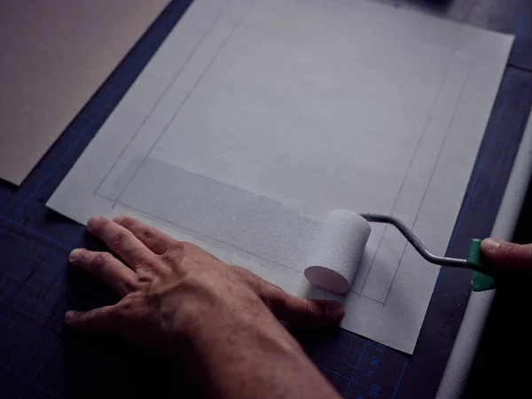 Ekin Zanaatkarının Elinde Silindir Profesyonel Ciltleme Yapıştırıcısı Ile Işaretlenmiş Kağıtlar — Stok fotoğraf