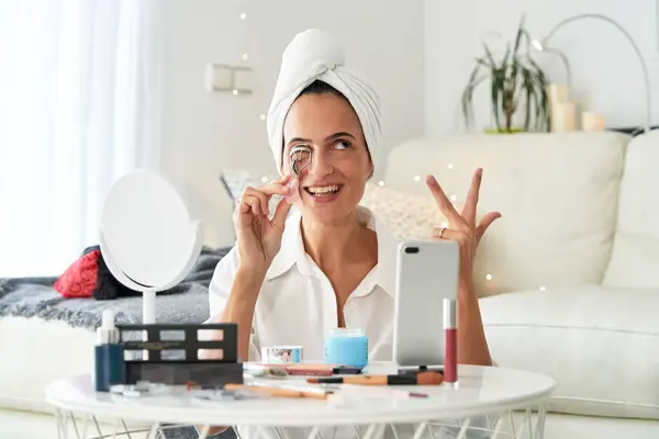 Wesoły Blogerka Kobieta Ręcznikiem Głowie Pomocą Lokówki Rzęsy Podczas Makijażu — Zdjęcie stockowe