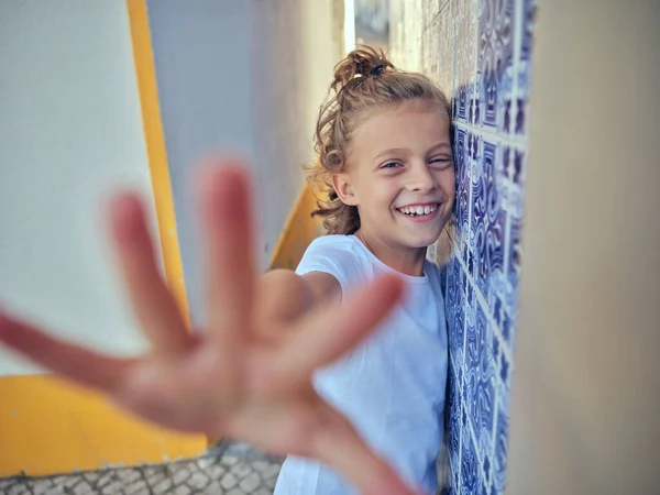 Χαμογελαστό Παιδί Στέκεται Κοντά Τζάμια Τοίχο Στο Στενό Πεζοδρόμιο Στους — Φωτογραφία Αρχείου