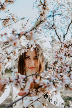 Bahçedeki ağaçların arasında mutlu bir kadın