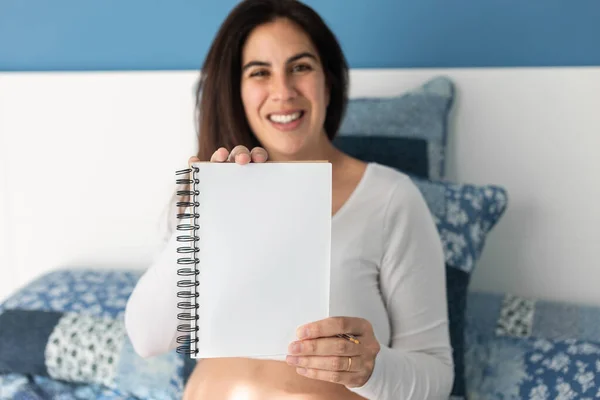 Těší Těhotná Žena Sedí Měkké Posteli Doma Ukazuje Prázdný Poznámkový — Stock fotografie