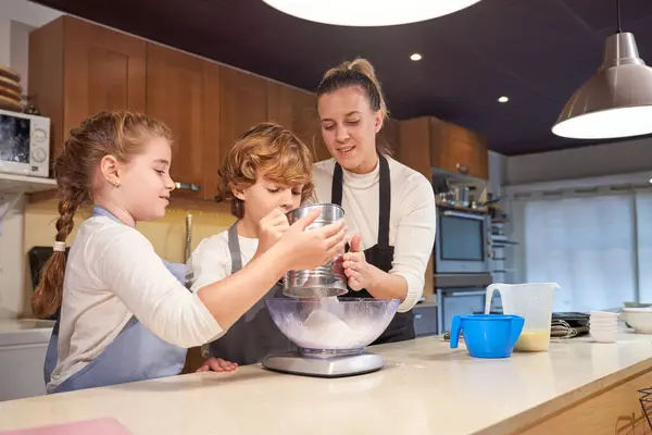 Dzieci Wylewając Mąkę Sita Misce Łuski Pomagając Mamie Kuchni Ciesząc — Zdjęcie stockowe