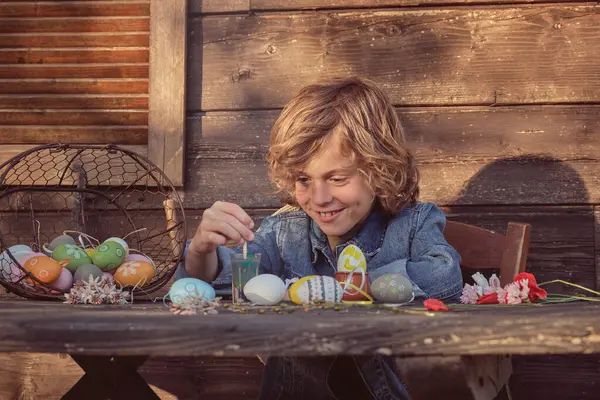 Милый Маленький Ребенок Рисует Яйца Пасху Деревянным Столом Солнечный День — стоковое фото
