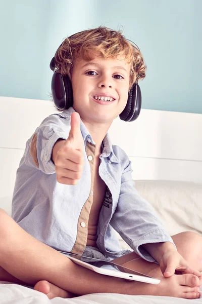 Pozytywne Boso Chłopiec Siedzi Skrzyżowanymi Nogami Cieszyć Się Piosenkami Tabletu — Zdjęcie stockowe