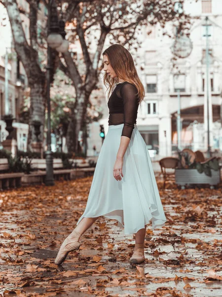 秋天的一天 站在黄叶飘落的公园里 站在尖尖鞋子里的年轻芭蕾舞女舞女伸展着脚趾头的侧影 — 图库照片