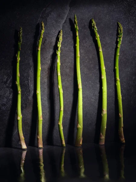 Many Whole Green Vitamin Asparagus Stems Placed Reflective Surface Gray — Stock Photo, Image