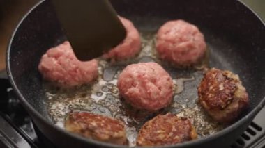 Yüksek açılı gerçek zamanlı aşçı tavada kızartılmış spatulayla pirzola yapıyor.