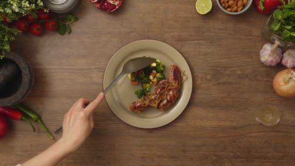 作物匿名厨师把新鲜的绿色沙拉放在盘子里 自制香肠放在木制桌子上的头像 — 图库视频影像