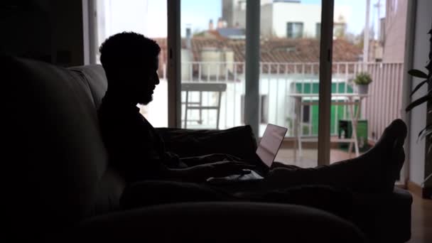 Odaklanmış Afrika Kökenli Amerikalı Bir Erkeğin Silueti Bilgisayarında Yazarken Evden — Stok video