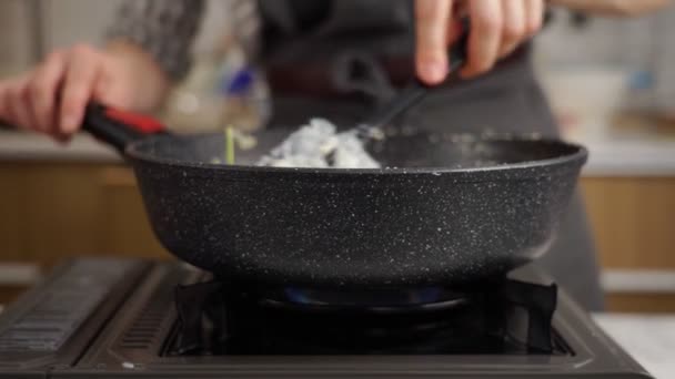 真正的时间匿名厨师搅拌与黑色通心粉意大利面和奶酪菠菜和奶油在油锅 — 图库视频影像