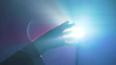 Uzamış kollu, VR kulaklık takan tanınmayan bir kadın, projektör aydınlatmasıyla duvarın yanındaki mavi neon ışığı altında sanal gerçekliği keşfediyor.