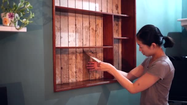 Azjatycka Kobieta Odrywa Starą Warstwę Farby Drewnianych Półek Przygotowując Się — Wideo stockowe