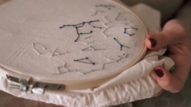 Hafif atölyede otururken çember ve iplikçik nakışlı yıldız takımyıldızlarının yan görünümü