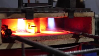 Eriyen yüksek sıcaklıktaki kalorifer ocağında yanan metal aletler.