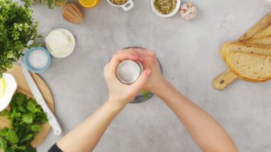 Tanınmayan bir bayanın taze avokadoyu kaju ve ekşi kremayla karıştırıp baharat ve limon suyu eklerken mutfakta tost sosu hazırlayışının en üst görüntüsü.