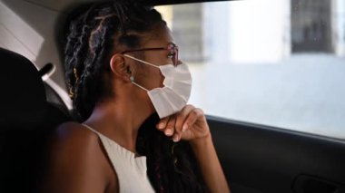 Arabadaki maskeli Afro-Amerikan kadın.