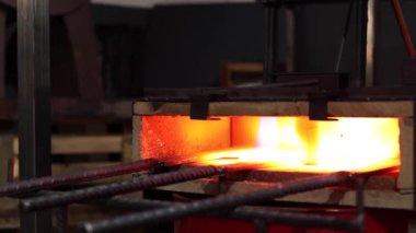 Eriyen yüksek sıcaklıktaki kalorifer ocağında yanan metal aletler.