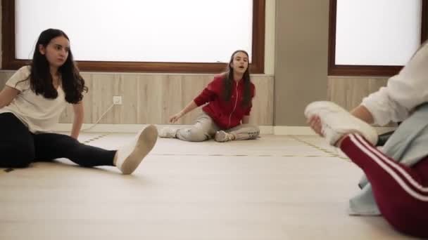 Гибкие Танцовщицы Сидят Полу Растягивают Ноги Время Подготовки Уроку Просторном — стоковое видео