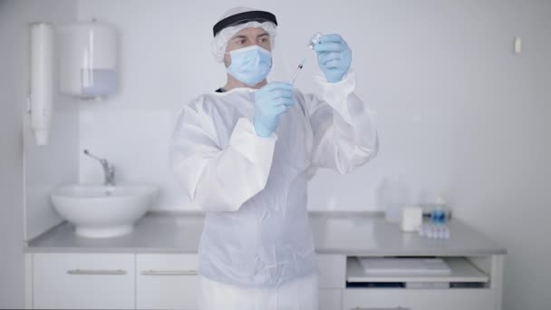 Crop Fokussierte Professionelle Männliche Arzt Chirurgenmantel Handschuhe Und Gesichtsschutzspritze Füllung — Stockvideo